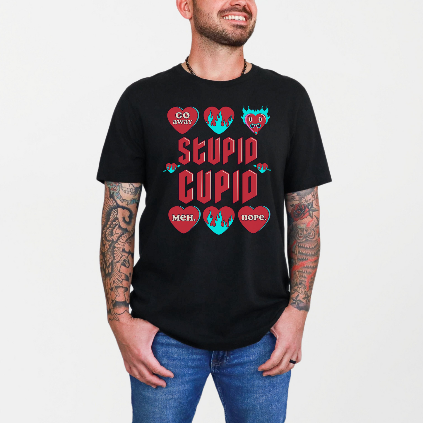 Image: Stupid Cupid Anti Valentines Day T-shirt, Unisex adult breakup shirt- this tee has large red 90s style text that reads Stupid Cupid, surrounded by conversation hearts that are on fire, or say Go Away, Meh, Nope. Great for divorce, by jaecrece