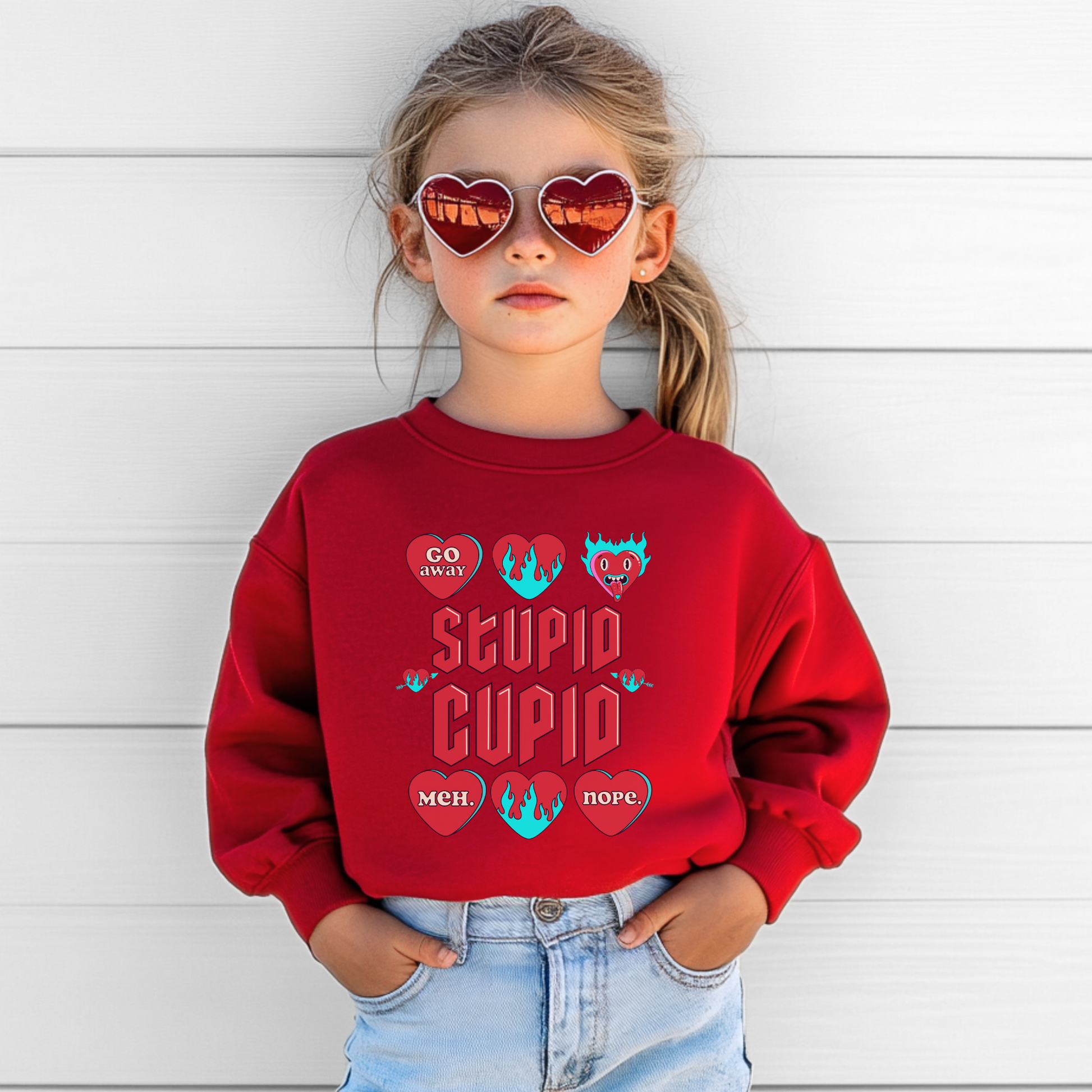 Image: Stupid Cupid Anti Valentines Day T-shirt for Kids. This sweatshirt is for girls and boys with red 90s style text that reads Stupid Cupid, with conversation hearts that are on fire, or say Go Away, Meh, Nope. Great for school party, by jaecrece