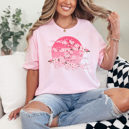 Image: A pink cherry blossom t-shirt featuring a delicate sakura tree design. The soft, durable fabric offers comfort, while the classic fit makes it versatile for any occasion. Perfect for springtime celebrations, Japanese aesthetic lovers, and those who appreciate kawaii fashion. Ideal as a gift for teens and adults. 