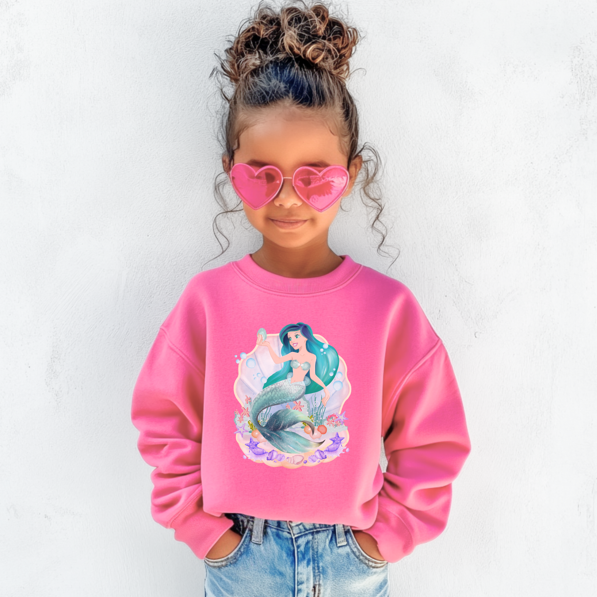 Image: Mermaid Sweatshirt for Little Girls. Pullover crewneck sweatshirt features a mermaid with blue hair and scales, swimming in a shell, with bubbles and seashells. This mermaidcore sweater is available in white, navy and hot pink, by jaecrece