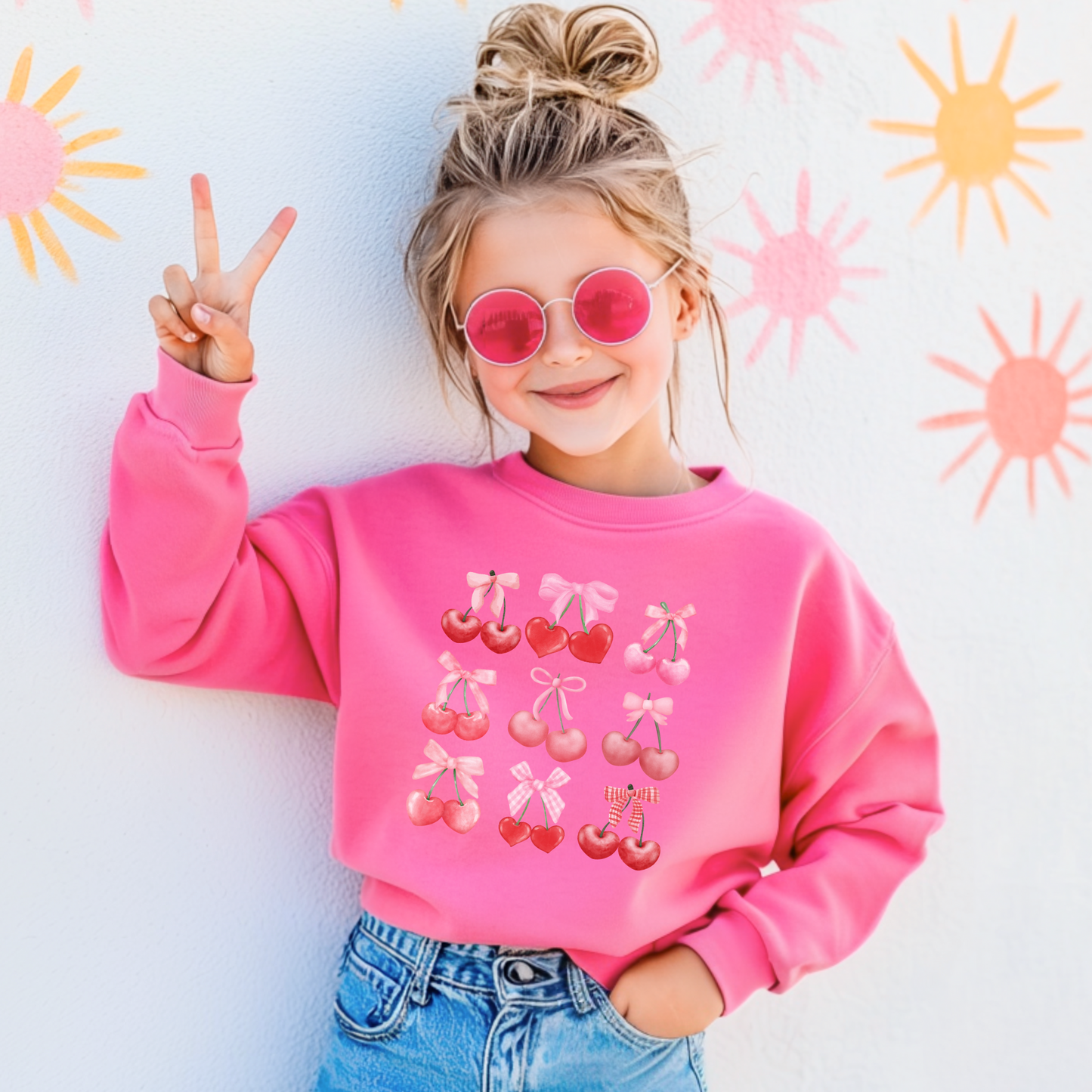 Image: Cherry Bow Girls Sweatshirt, available in Hot pink, White and dark gray. This coquette aesthetic shirt features 9 different cherries with bows, making a large soft girly graphic. Makes a great Valentines gift for toddlers and little girls, by jaecrece