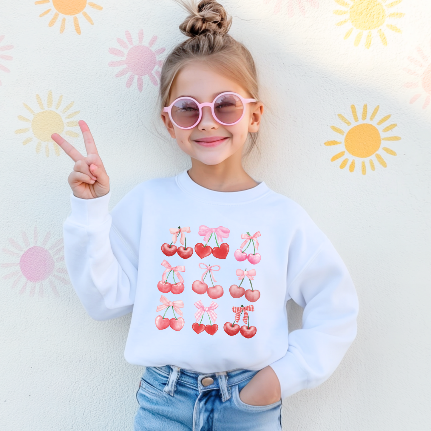 Image: Cherry Bow Girls Sweatshirt, available in Hot pink, White and dark gray. This coquette aesthetic shirt features 9 different cherries with bows, making a large soft girly graphic. Makes a great Valentines gift for toddlers and little girls, by jaecrece