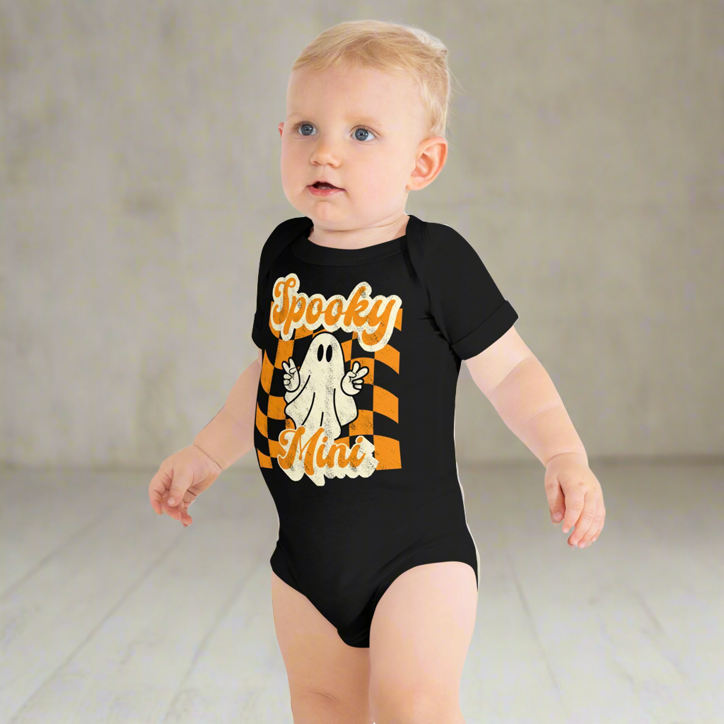 Spooky Mini Baby Bodysuit onesie, featuring an orange checkerboard pattern with a cute ghost and the text Spooky Mini, by jaecrece