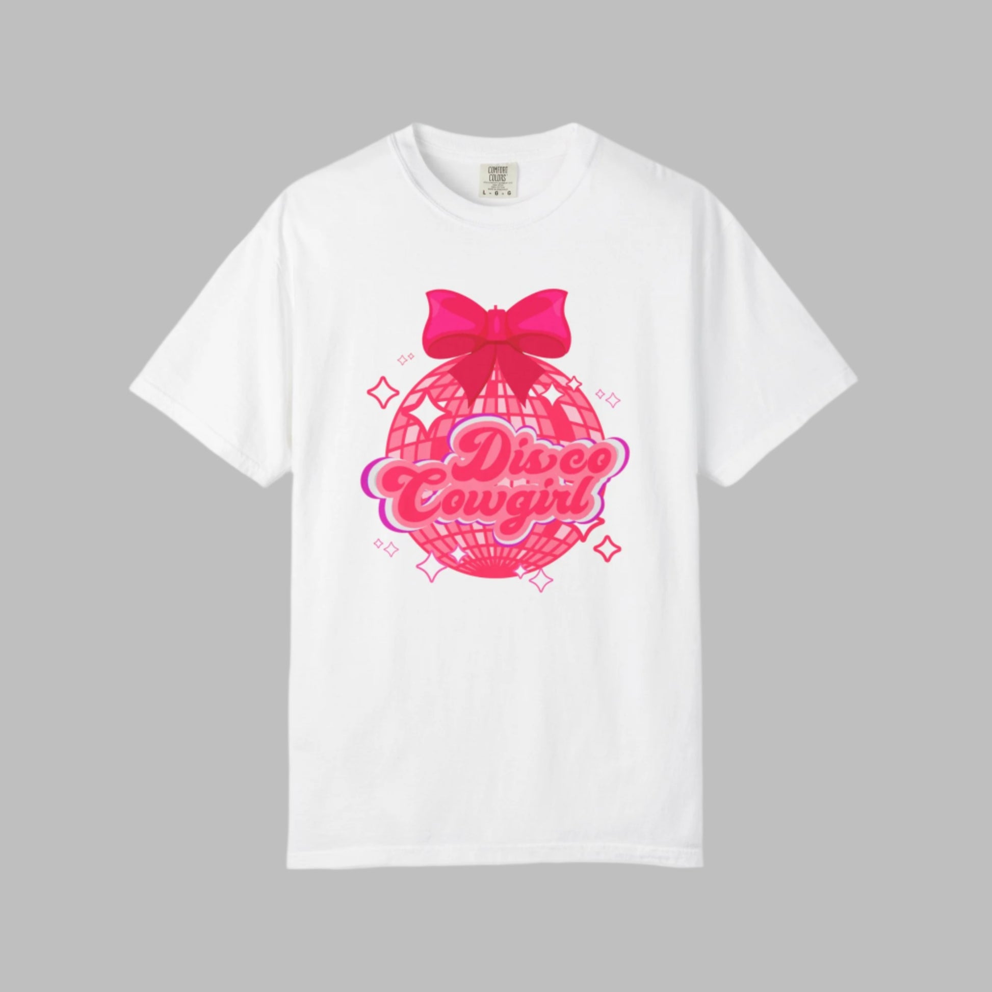 Comfort Colors Disco Cowgirl tee for women featuring bold pink script, sparkly disco ball, and hot pink bow for a festive coquette vibe. Great for rodeo season, girls' trips, and honky tonk nights. A retro-inspired western shirt made for comfort and fun in black, pepper, ivory, and white, S–4XL. Matching sweatshirt available for the full look.