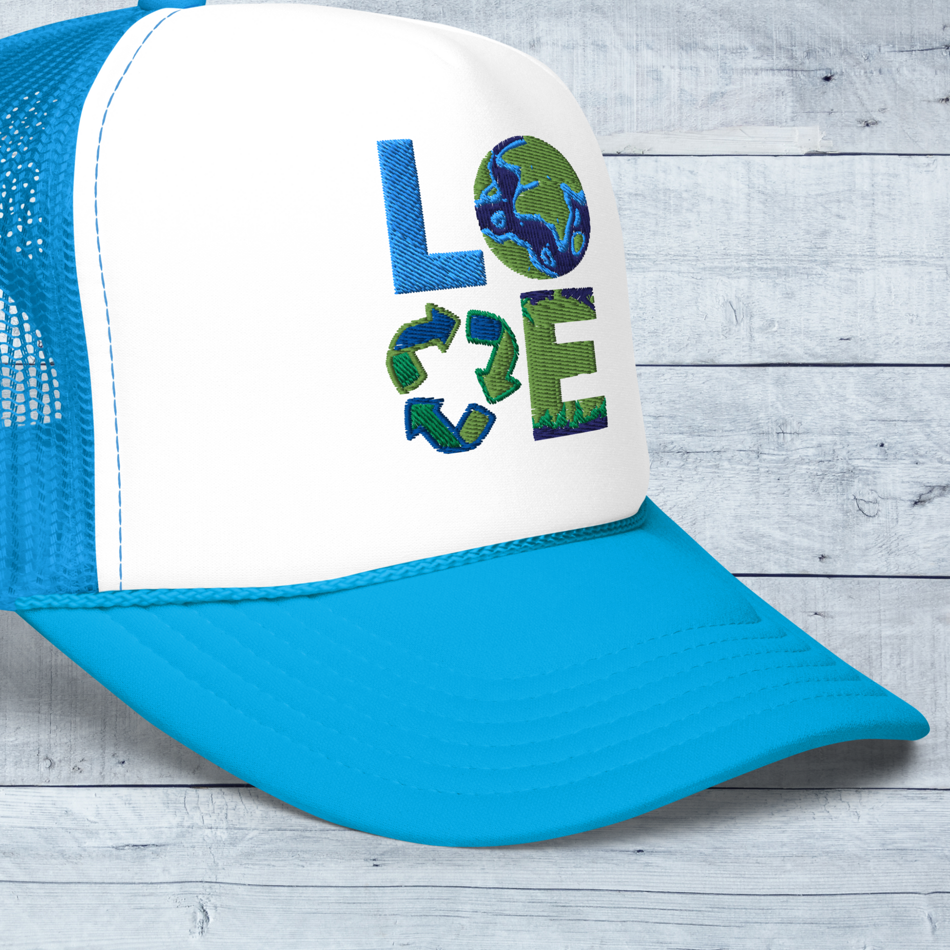 Image: Earth Day Foam Trucker Hat. This Save the Planet Unisex Hat has a teal blue bill and mesh back. The front of the baseball cap has LOVE embroidery to represent our planets oceans, plants and a commitment to reduce reuse and recycle, by jaecrece