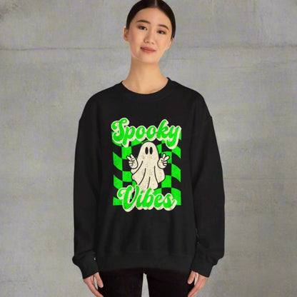 Black Halloween Unisex sweatshirt, featuring a green checkboard pattern, cute ghost giving the peace sign, and the text Spooky vibes, by jaecrece