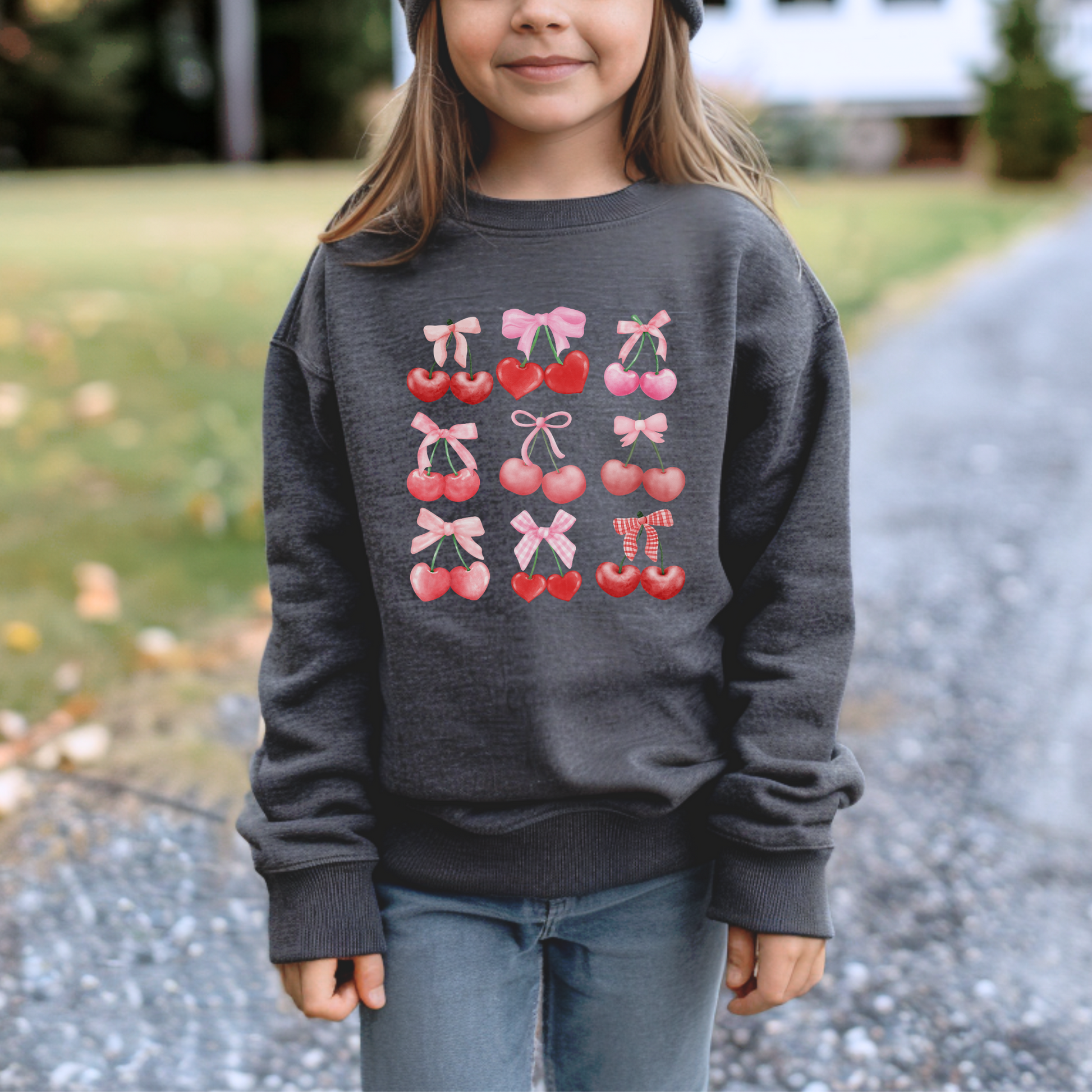 Image: Cherry Bow Girls Sweatshirt, available in Hot pink, White and dark gray. This coquette aesthetic shirt features 9 different cherries with bows, making a large soft girly graphic. Makes a great Valentines gift for toddlers and little girls, by jaecrece