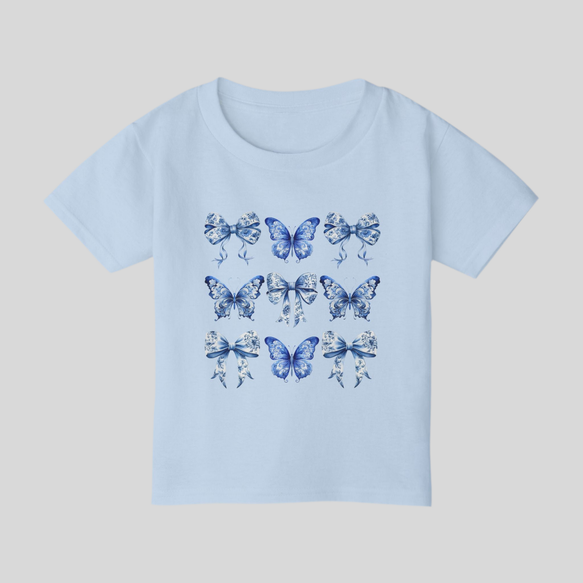 Blue Toile toddler tee for girls features a classic butterfly and bow motif in soft blue hues, perfect for fans of cottagecore, Texas coquette trends, and coastal cowgirl style. Designed for comfort and charm, this cute spring shirt for toddlers is ideal for everyday play or family matching moments. Sizes 2T to 6T make it easy to twin with older siblings or moms. An aesthetic, versatile gift for fashionable little ones, by jaecrece.