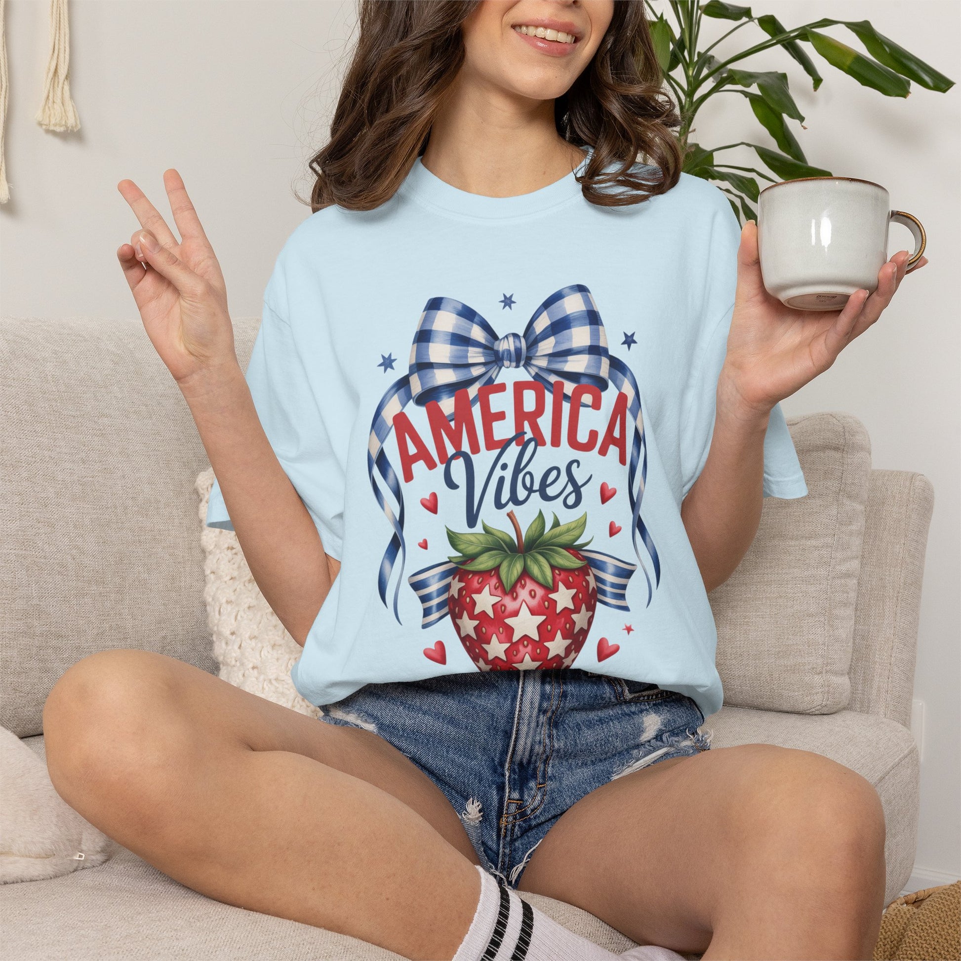 Comfort Colors patriotic strawberry shirt celebrating America 250 and the 250th anniversary of the United States with hand drawn strawberry artwork gingham bow accents and patriotic stars. Soft relaxed fit cotton tee in white chambray and blossom colors. Ideal for 4th of July family outfits mommy and me matching looks summer barbecues patriotic parades and vintage Americana inspired everyday fashion
