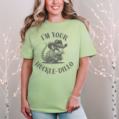 Image: A funny and unique western T-shirt featuring a dark grey armadillo illustration dressed as a sheriff. The armadillo sports a cowboy hat with a small Texas emblem and a rugged sheriff’s jacket, making it a great fit for fans of country style fashion and Texas culture. A great conversation starter, this unisex tee is perfect for armadillo lovers, animal enthusiasts, or anyone who enjoys quirky and humorous designs, by jaecrece.