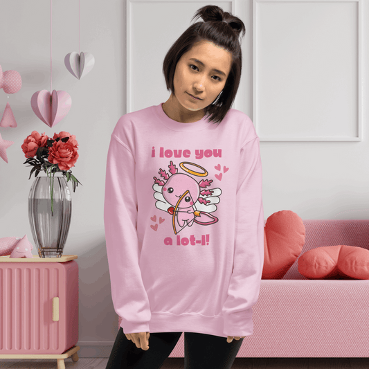 A woman wearing a light pink unisex Valentine sweatshirt featuring a cute axolotl cupid graphic with wings, halo, heart accents, and the phrase I love you a lot l. The soft pastel color highlights the playful Valentine design while the classic crewneck fit offers cozy comfort for casual winter outfits. Perfect for Valentine’s Day celebrations, Galentine’s gatherings, and matching family outfits with kids and toddlers.