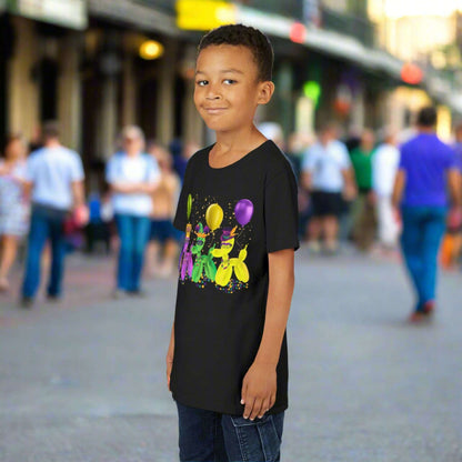 Let kids celebrate Mardi Gras in style with this youth-sized black t-shirt featuring festive balloon dogs in gold, purple, and green. The playful “walk it like a dog” theme captures the fun of New Orleans parades and French Quarter street celebrations. With beads, confetti, and Carnival hats, it’s made for matching the whole family and showing off that Mardi Gras pride all season long.
