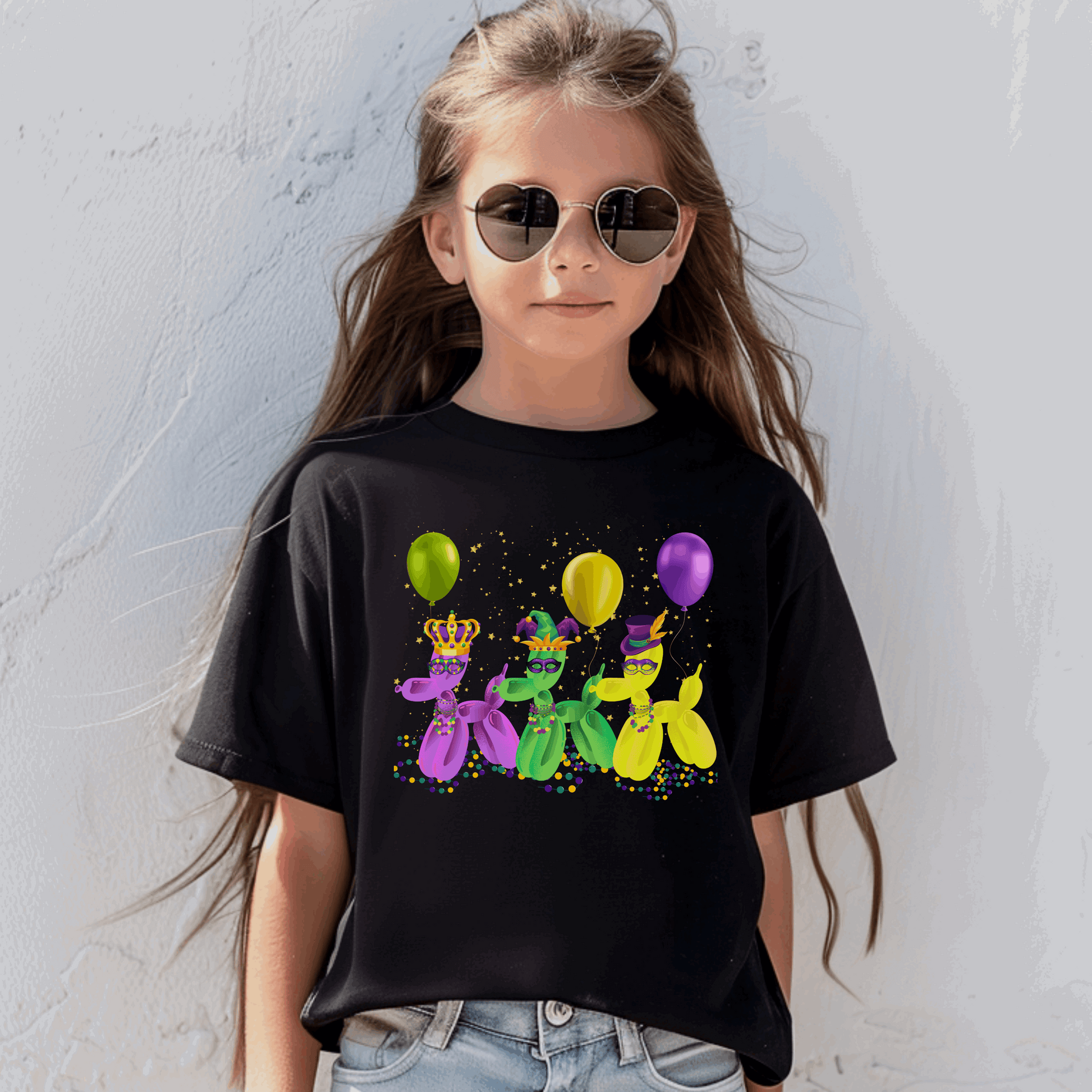 This Mardi Gras youth t-shirt in black shows off three festive balloon dogs with masks, hats, and confetti, capturing the spirit of the French Quarter. Perfect for family matching looks during Mardi Gras parades in New Orleans. Whether dancing in the street or shouting for beads, kids will love the playful "walk it like a dog" vibe of this Carnival-ready outfit for boys and girls.