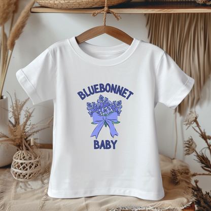White t-shirt with bluebonnet design and text on a hanger against a neutral background