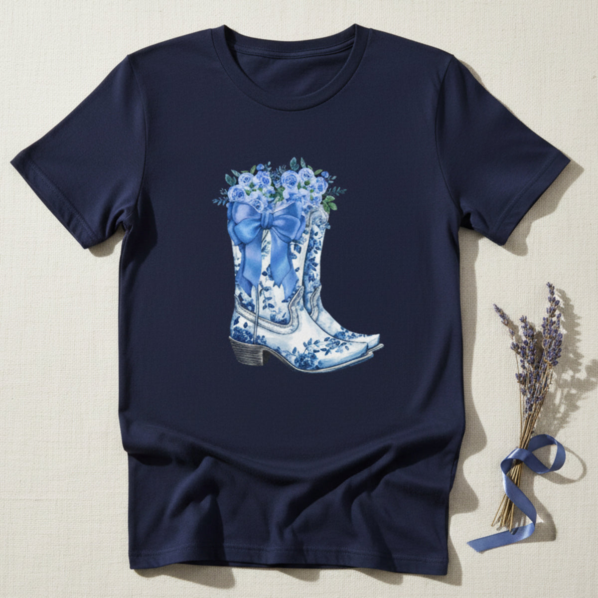 Image: Designed for girls in sizes S to XL, this country chic shirt features a whimsical scene of cowgirl boots, a blue ribbon, and floral accents. A coastal cowgirl favorite, this pullover adds just the right touch of southern sweetness to any outfit. Ideal for daughters who love soft blues, western vibes, and cozy statement pieces they can wear anywhere, by jaecrece.