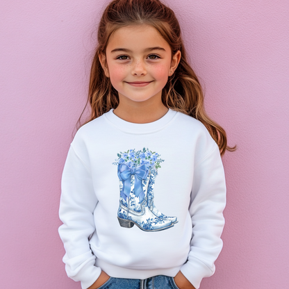 Image: Blue Toile Boots and Bows Sweatshirt in sizes for girls and toddlers. This pullover sweater features a pair of coastal cowgirl aesthetic cowboy boots with a blue bow and blue wildflowers. This country themed sweater makes a perfect gift for your daughter, by jaecrece