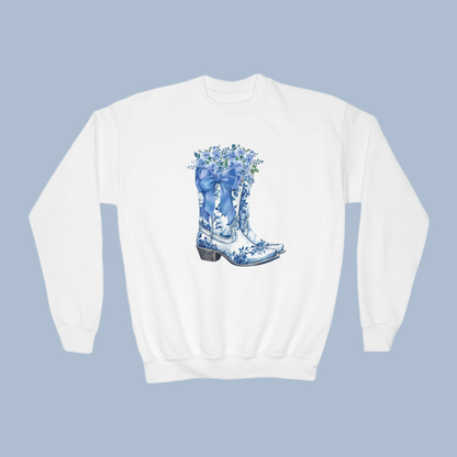 Image: Blue Toile Boots and Bows Sweatshirt in sizes for girls and toddlers. This pullover sweater features a pair of coastal cowgirl aesthetic cowboy boots with a blue bow and blue wildflowers. This country themed sweater makes a perfect gift for your daughter,  by jaecrece