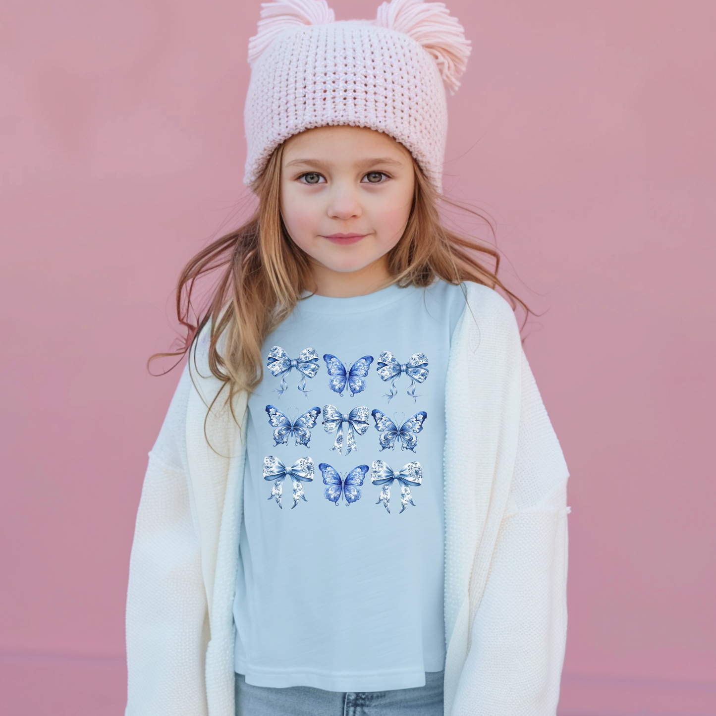 Image: Blue Toile Butterflies and Bows girls T-shirt, made from soft Comfort Colors cotton in shades Chambray, White, True Navy, or Pepper. Sizes XS to XL. Designed with vintage flair and trending soft girl appeal, this shirt features a lovely print ideal for family gatherings or weekend wear. Pair it with denim, skirts, or matching pieces for a full look, by jaecrece.