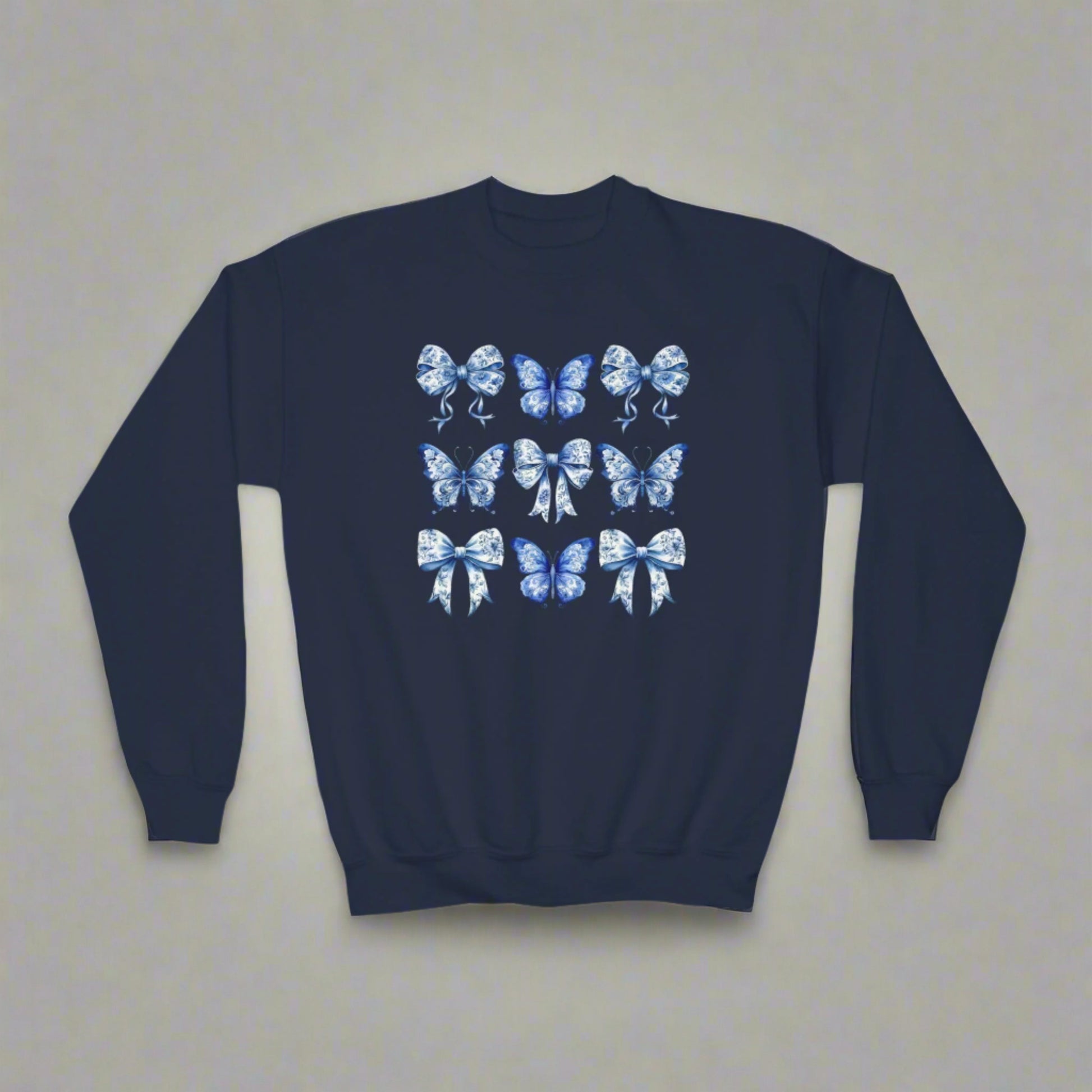 Blue Toile Girls Sweatshirt with delicate bow and butterfly details in a classic navy and white toile pattern. Sizes XS–XL fit girls and tweens comfortably. Soft and cozy, perfect for spring or fall layering, casual outfits, or family events. Embraces soft girl aesthetic, Texas coquette, coastal cowgirl, and whimsical cottagecore trends. Part of a matching family collection, ideal for sibling coordination or mom and daughter photo outfits. Makes a thoughtful birthday gift or stylish wardrobe staple for girl