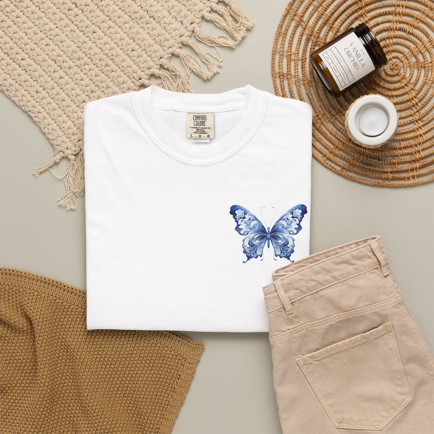 Comfort Colors 1717 oversized tee for women featuring a delicate blue toile butterfly on the left chest pocket area. Soft garment dyed shirt available in five colors and sizes S through 4XL. This chinoiserie inspired butterfly design blends French country charm with quiet luxury style. Perfect for casual outfits, coastal grandmother looks, cottagecore fashion, clean girl basics, summer travel wardrobes, boutique gifts, and everyday relaxed comfort with vintage elegance.