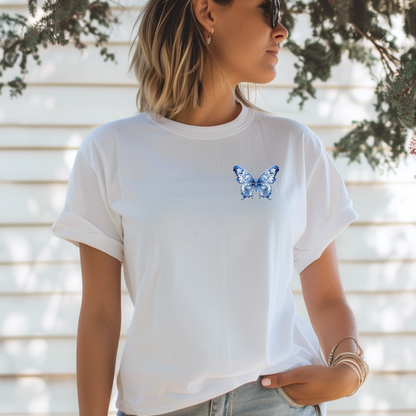 Elegant yet easygoing Comfort Colors women's tee featuring a blue toile butterfly graphic at the upper chest. Soft, breathable cotton and muted hues make this shirt ideal for minimalist wardrobes that still embrace French design and coquette vibes. Wear with jeans, skirts, or layered under cardigans for a cozy, nature-inspired look that’s both classic and fresh.