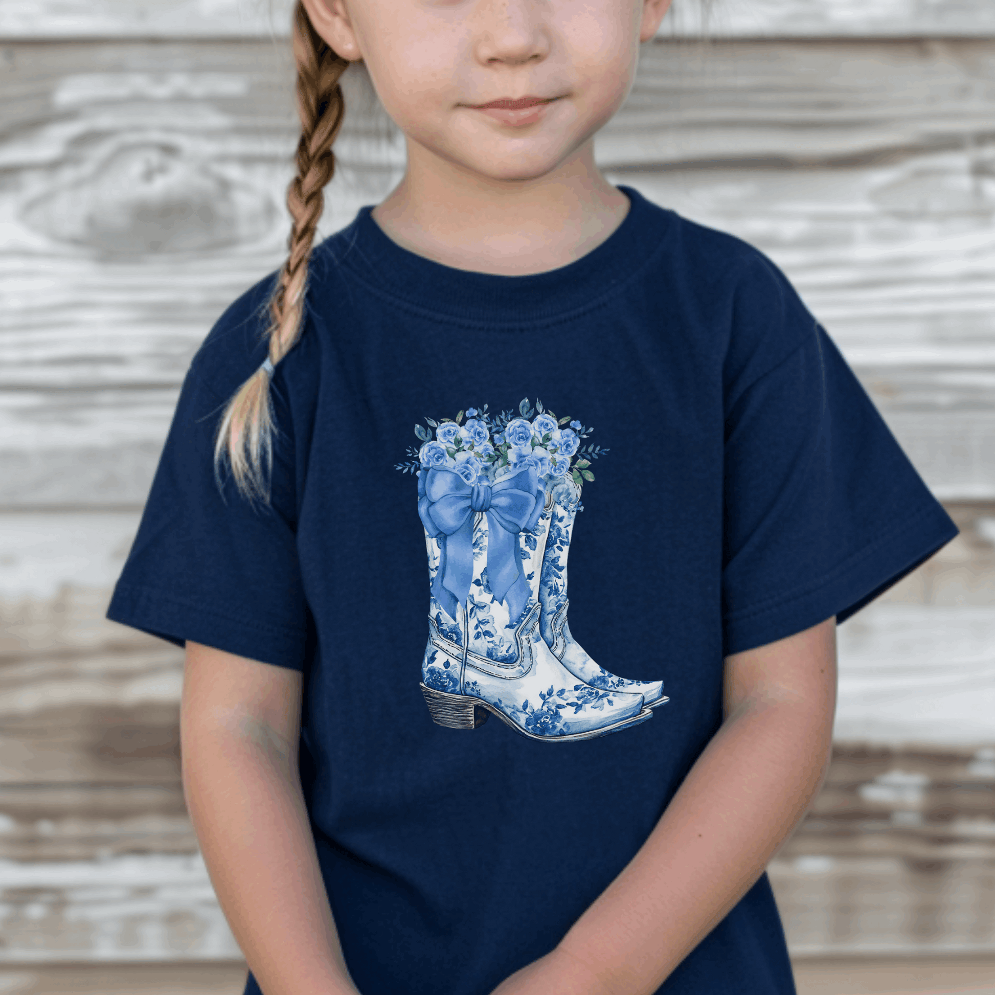 This Blue Toile Floral Cowboy Boots Toddler Tee is perfect for little ones who love western style with a soft girl twist. Featuring a detailed blue toile de jouy pattern and chic cowgirl boots, this toddler graphic shirt blends classic French aesthetic with Texas charm. Ideal for rodeo days, Western-themed parties, or everyday adventures. A must-have for fans of bougie mama style, blue toile fashion, and toddler western outfits.