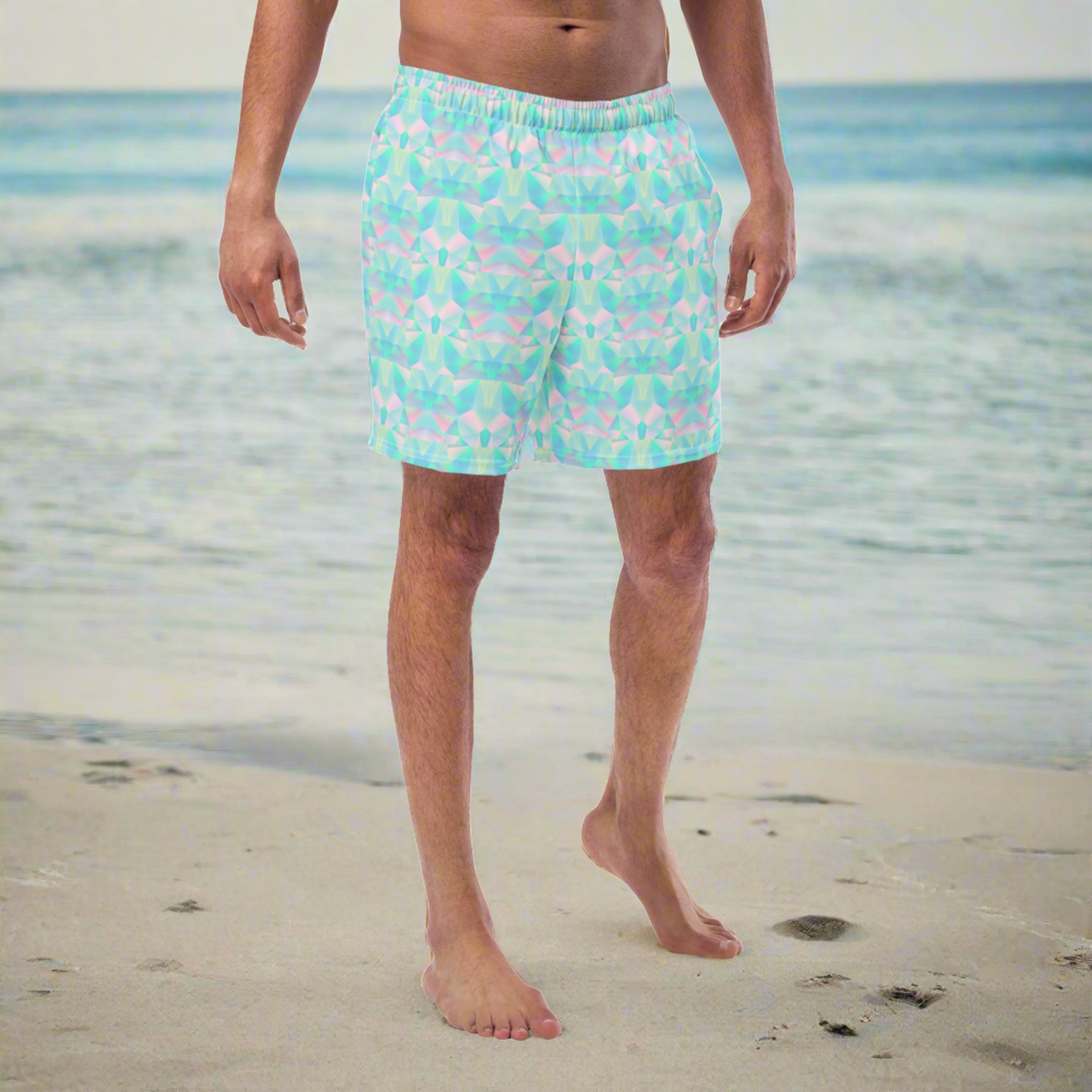 Person wearing blue geometric swim shorts on a beach