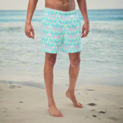 Person wearing blue geometric swim shorts on a beach