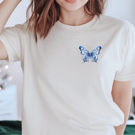 Women's Comfort Colors T-shirt featuring a delicate blue toile butterfly design on the upper left chest. This soft girl aesthetic tee blends French cottagecore style with vintage charm, perfect for bougie mamas, butterfly lovers, and fans of the coastal cowgirl vibe. Made from 100% ring-spun cotton, it's breathable, soft, and ideal for everyday wear, lounging, or layering with your favorite wardrobe staples.

