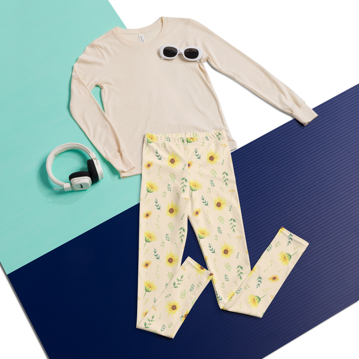 Girls yoga pants featuring a botanical wildflower print with yellow sunflowers, green foliage and smaller flowers scattered across a creamy background. The soft stretchy fabric allows comfortable movement during yoga, stretching, play and everyday activities. The high rise waistband and full length design make them easy to wear with casual tops and sneakers. The cottagecore floral pattern adds a cheerful nature inspired touch to an everyday girls wardrobe.