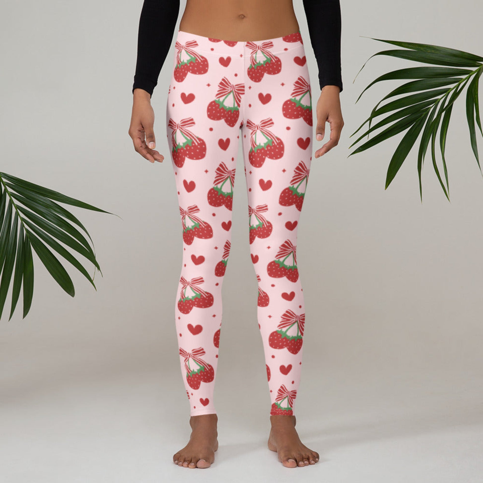 Image: These coquette inspired leggings are made for women who love playful prints and soft, stretchy comfort. Decorated with red bows and strawberry accents on a pink base, they’re perfect in sizes XS through XL. Whether paired with ballet flats, hoodies, or tank tops, these leggings offer endless outfit options for those who adore girly details with a modern twist, by jaecrece.