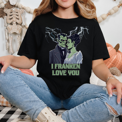 Cute and spooky Halloween graphic shirt with romantic Frankenstein and bride, lightning background, “I Franken Love You.” Soft black unisex Gildan 64000 tee, S-5XL, perfect for Halloween humor, date night, or unique Halloween gifts for her or him.