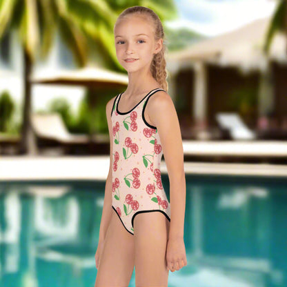 Disco Cherries girls swimsuit in toddler sizes 2T–7, made with UPF 38–40 sun protection and soft microfiber stretch fabric. Red disco cherries pop against a pink background for a fun, eye-catching look. Ideal for beach days, pool playdates, or vacation twinning. Matches perfectly with our adult-sized version for coordinated family swimwear that’s stylish and fun.

