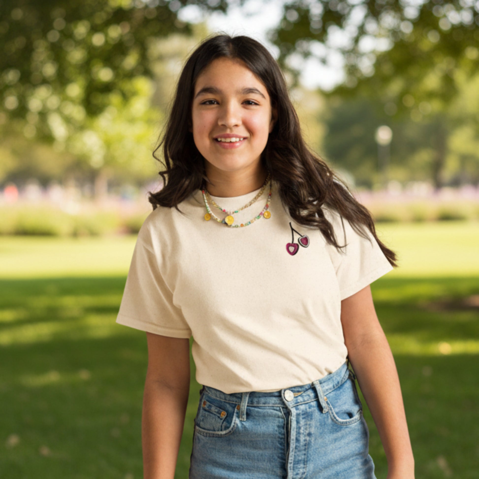 Girls embroidered cherry tshirt in soft cotton with delicate heart shaped cherries stitched on the chest. Available in white, natural, and azalea, this sweet and simple top is perfect for school days, playdates, and summer outings. Designed with a soft girl and coquette aesthetic in mind, it pairs easily with denim shorts, skirts, or leggings for an effortless everyday outfit. A cute boutique style piece for girls who love playful, girly details.