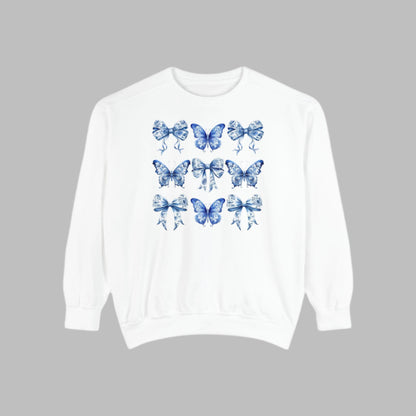 Image: A cozy and cute pullover sweatshirt featuring a nostalgic blue toile pattern with butterfly and ribbon illustrations. Designed for women in sizes XS to XL, this sweatshirt brings elegance to everyday comfort. Match it with your little one in our toddler and youth pieces to create adorable family memories and coordinated style, by jaecrece.