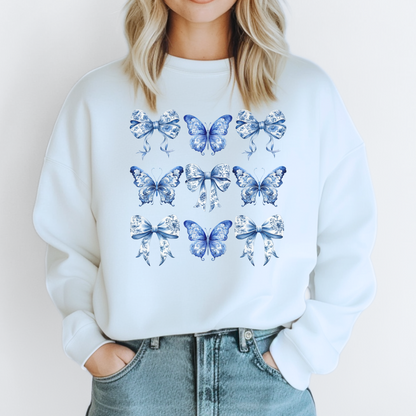 Image: Blue toile de jouy patterned women’s sweatshirt with butterfly and bow elements, reflecting a soft Western aesthetic with Southern roots. Ideal for stylish moms who love a cute and cozy pullover for errands, events, or casual days. Available in sizes XS to XL and matches toddler and youth outfits for adorable family style, by jaecrece.