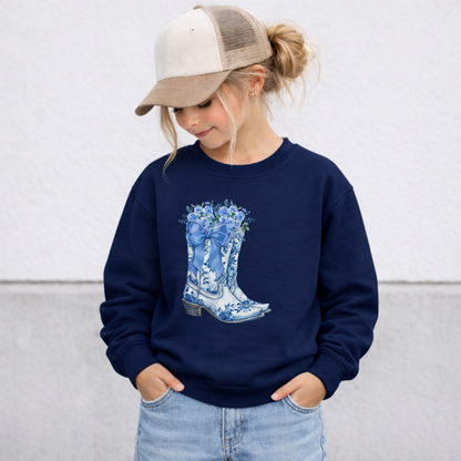 Navy girls sweatshirt with a blue and white toile boots design featuring floral cowboy boots and botanical accents. This cozy crewneck pullover is designed for girls who love Western fashion, country inspired clothing, feminine details and unique graphic sweatshirts for everyday wear.