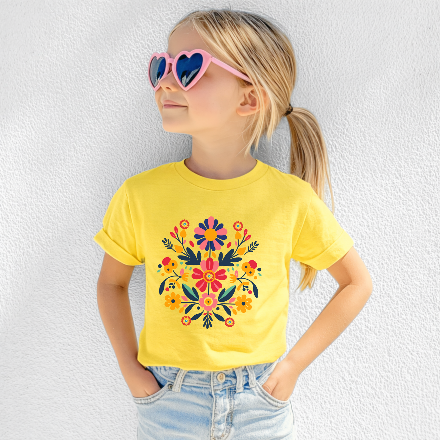 Colorful Mexican Otomi Folk Art girls tshirt featuring vibrant floral and botanical artwork inspired by traditional Otomi designs printed on a Gildan 5000B youth tee in sizes XS through XL. Bright folk art graphic with cheerful colors makes this girls graphic tshirt perfect for school outfits, family vacations, birthday parties, Fiesta celebrations, and Mommy and Me matching outfits. Available in White, Daisy, Sapphire, Light Pink, and Charcoal with Free U.S. Shipping from JaeCrece.