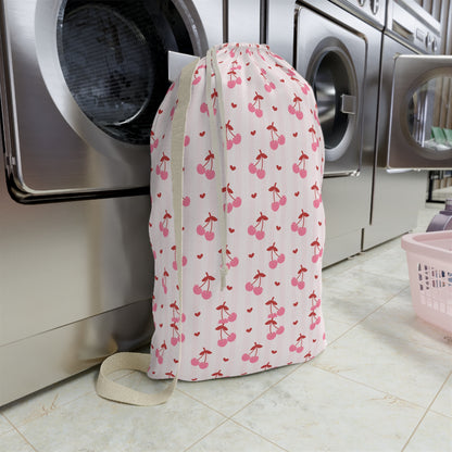 Personalized coquette cherry laundry bag designed with a charming cherry print and custom name personalization. This spacious drawstring bag is perfect for storing dirty clothes, towels, and bedding during family vacations, college life, summer camp, and everyday use. Its lightweight construction and roomy interior make organizing laundry simple while adding a feminine touch to bedrooms, dorm rooms, and travel accessories. A thoughtful personalized gift for students, travelers, and anyone who loves cute org