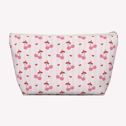 Pink cherry toiletry pouch with custom name detail and playful coquette aesthetic designed for stylish everyday organization. This personalized makeup bag features vibrant cherry illustrations, scattered hearts, durable spun polyester fabric, and a roomy interior for cosmetics, toiletries, chargers, snacks, and self care essentials. Lightweight and travel friendly cosmetic case fits easily into tote bags, backpacks, luggage, and weekender bags. Great gift for birthdays, sleepovers, vacations, and bridal par