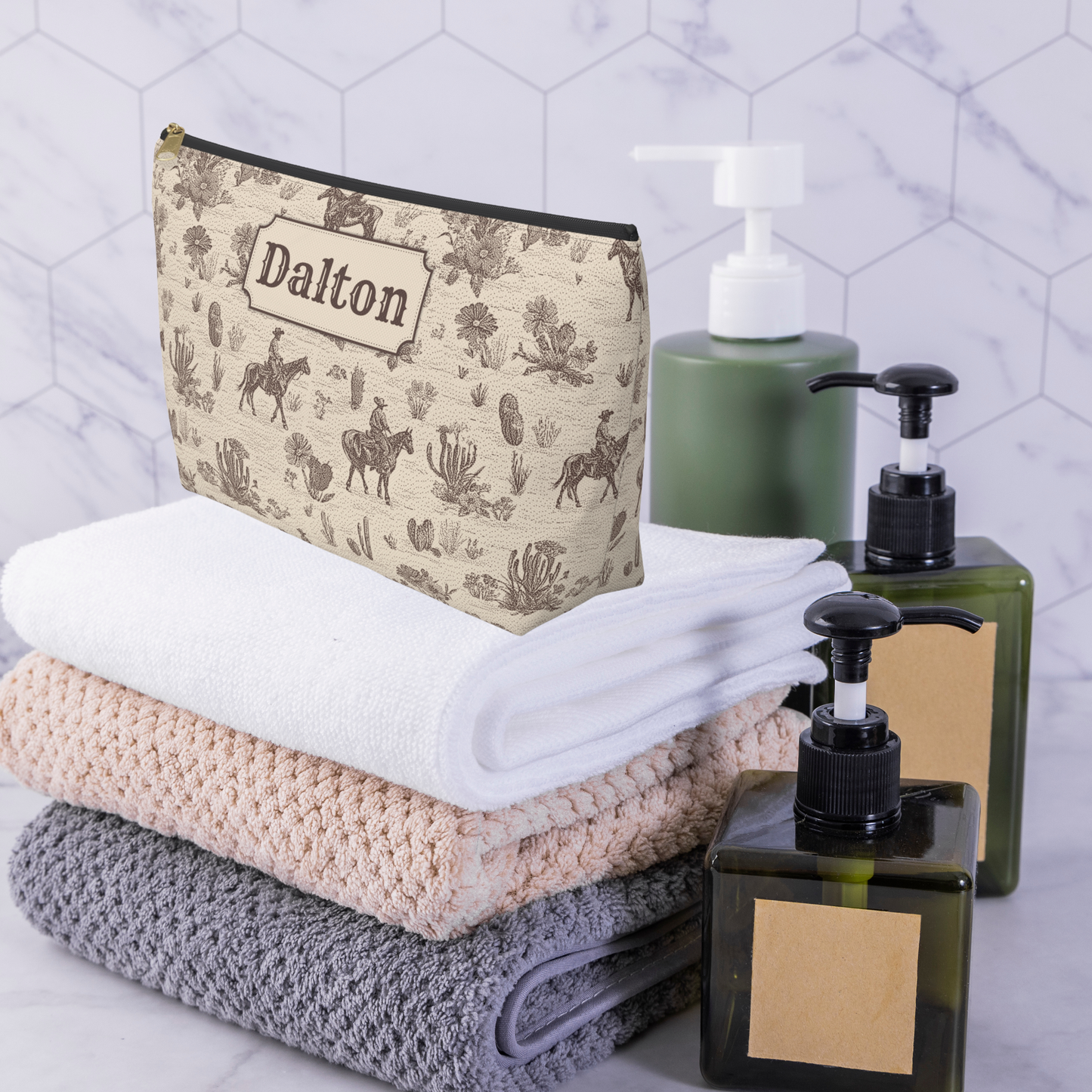 Personalized Western travel accessory bag with a vintage cowboy toile pattern in warm brown and cream. The detailed ranch inspired print features horses, cowboys on horseback, cacti and desert vegetation. This custom pouch can organize toiletries, shaving essentials, cosmetics, chargers and other small travel necessities.