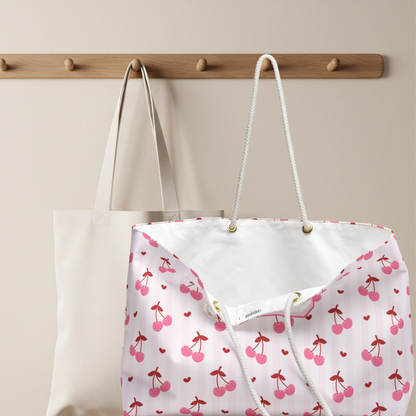 The personalized coquette cherry weekender bag shown from another perspective to display its spacious design and playful cherry print. This custom travel tote is perfect for carry on luggage, overnight stays, beach days, and weekend adventures. Personalized with a name, it becomes a unique gift for birthdays, graduations, Mother's Day, Christmas, or anyone who loves the soft girl and cherry aesthetic.