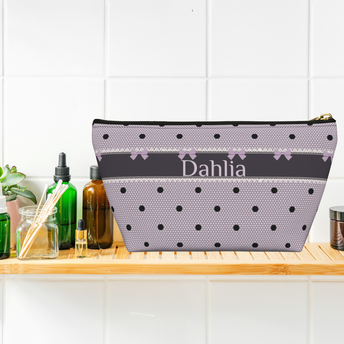 Black and lavender polka dot makeup bag featuring bows, lace inspired details and personalized lettering in an elegant style. This canvas zipper pouch combines gothic coquette and dark romance aesthetics with practical storage for cosmetics, skincare and toiletries. Customize it with a name or monogram for a unique travel accessory.