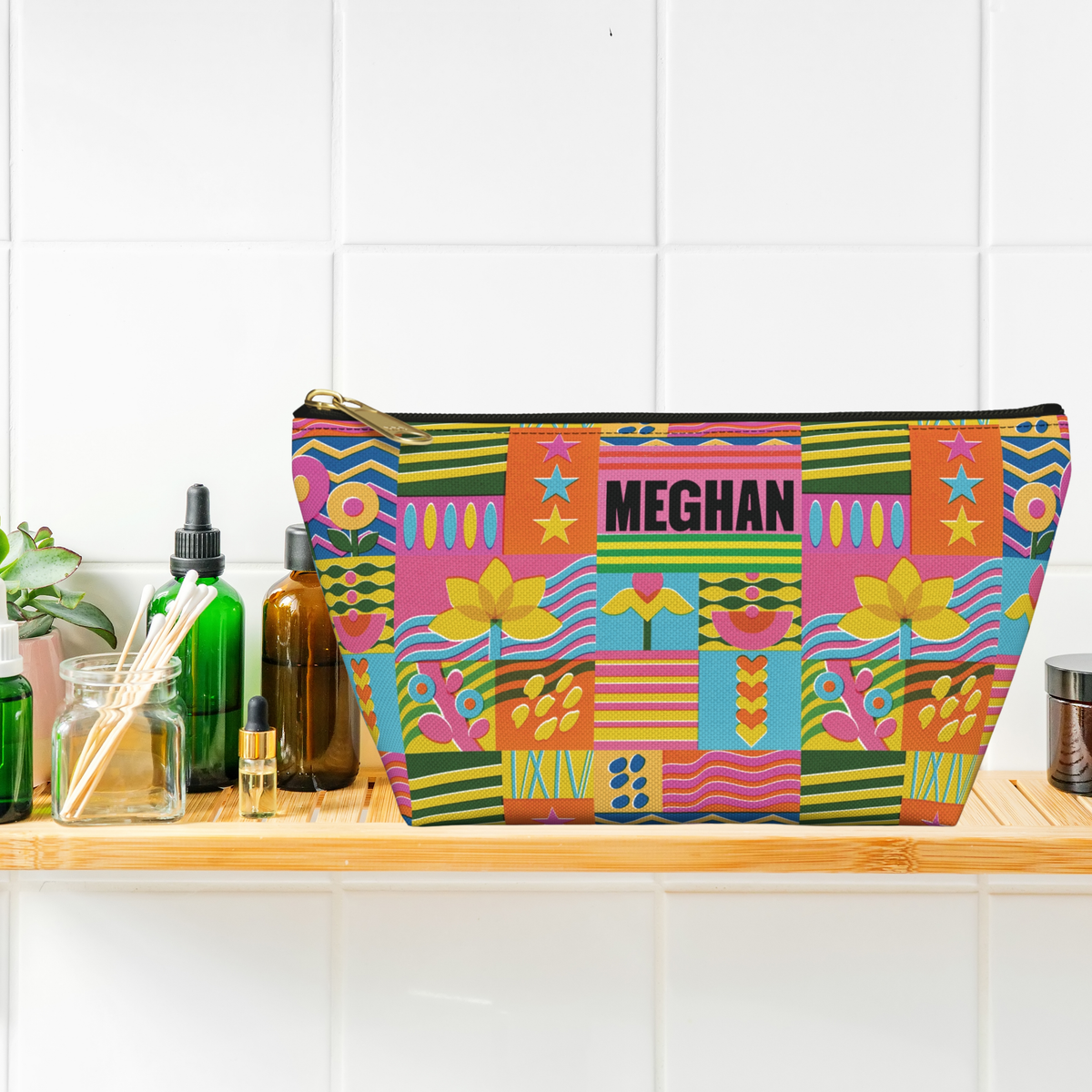 Personalized travel pouch for teen girls featuring a colorful retro floral pattern with bright flowers, stripes, wavy lines, stars, and geometric shapes. The custom name makes this cosmetic bag feel uniquely hers while the roomy design helps organize makeup, toiletries, hair accessories, jewelry, or other travel essentials. A fun gift for birthdays, Christmas, vacations, and special occasions.