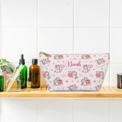 Small personalized unicorn zipper pouch displayed on a bathroom shelf, featuring a pastel rainbow unicorn design with a whimsical cutecore aesthetic and custom name. Cute personalized girls makeup bag or toiletry pouch for organizing beauty essentials, hair accessories and everyday items.