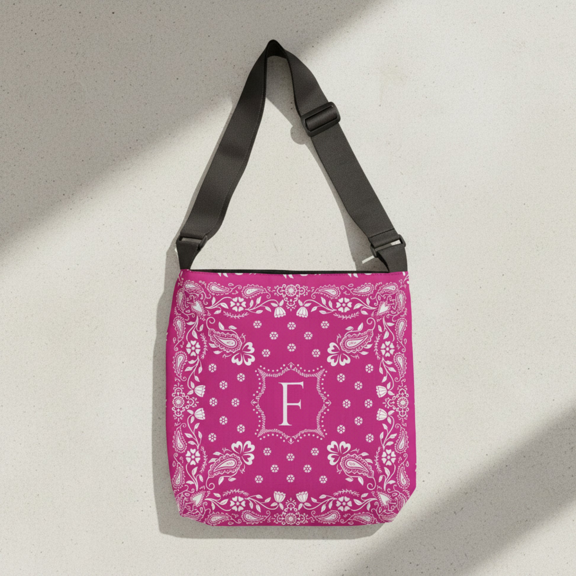 Custom hot pink western tote bag personalized with your initials and inspired by traditional bandana prints. Durable polyester construction with an adjustable strap, roomy interior, and inside pocket makes it perfect for errands, vacations, school, or weekend adventures.