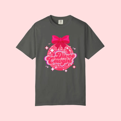 Disco Cowgirl tee for women in Comfort Colors is designed with a glittery pink disco ball, hot pink bow, and bright lettering. Ideal for matching party outfits, this retro western shirt is a cute coquette option for bachelorettes, rodeos, or girls' weekends. Available in S–4XL in multiple neutral shades for a flattering, oversized fit.