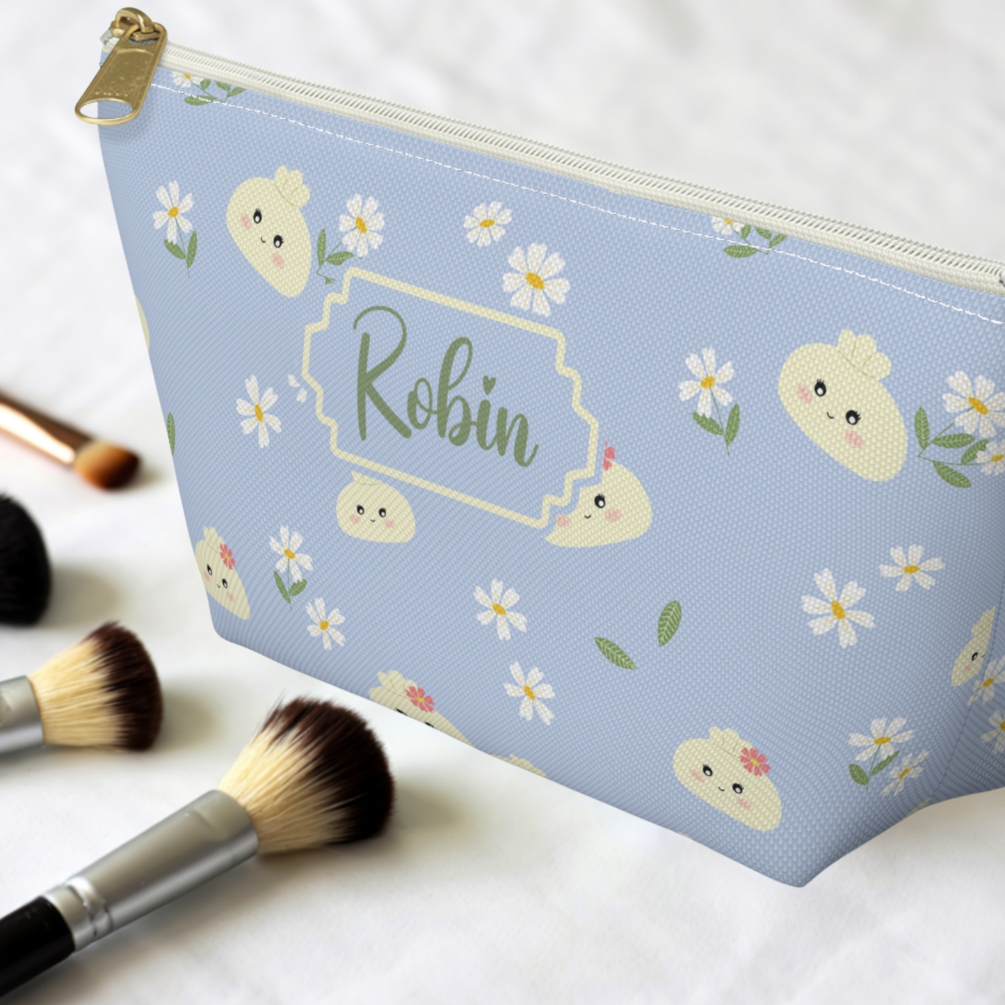 Cute Cutecore dumpling pouch featuring smiling cream dumplings, tiny white daisies, and green botanical accents on a soft pastel background. Personalized with your choice of name, font, and text color. This versatile zipper pouch can be used as a makeup bag, toiletry bag, travel pouch, pencil case, or organizer for small essentials.