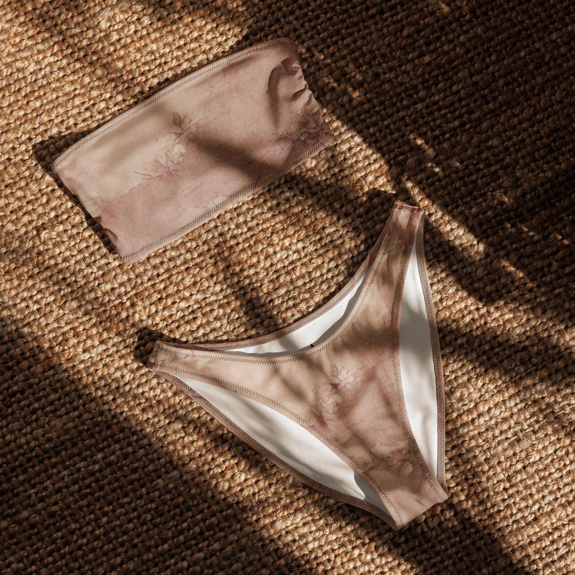 Flat lay of the Dusty Pink Cottagecore Bandeau Bikini showing the strapless top and high-leg V-cut bottoms. This soft girl aesthetic swimsuit features romantic pastel tones, made from eco-friendly recycled fabric with UPF 50+ protection. The simple yet elegant design makes it a perfect summer staple for beach days, pool lounging, or festival season. Available in inclusive sizes 2XS–6XL.