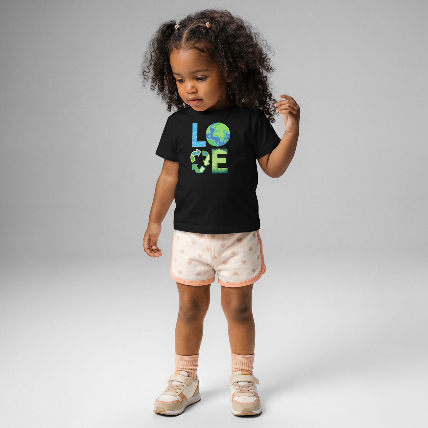 Eco conscious baby clothing featuring Earth Day graphic tee with Earth, recycling, and nature symbols